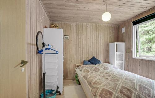 a small bedroom with a bed and a refrigerator at Amazing Home In Spttrup With House Sea View in Spottrup