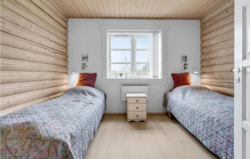 Gorgeous Home In Vggerlse With Kitchen في Bøtø By: سريرين في غرفة نوم مع نافذة