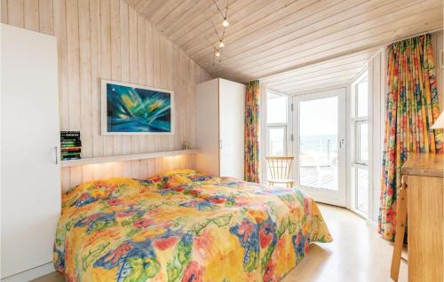 Un dormitorio con una cama colorida y una ventana en 4 Bedroom Awesome Home In Rnne, en Rønne