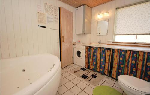 a bathroom with a tub and a toilet and a sink at Awesome Home In Hejls With 3 Bedrooms, Sauna And Wifi in Hejls