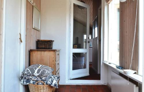 a hallway with a door and a chair in a room at 3 Bedroom Cozy Home In Hvide Sande in Havrvig