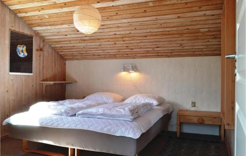 Cama en habitación con techo de madera en Amazing Home In Hvide Sande With 3 Bedrooms, Sauna And Wifi, en Havrvig