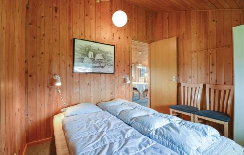 a bedroom with a bed in a wooden wall at Awesome Home In Hvide Sande With 3 Bedrooms And Wifi in Nørre Lyngvig