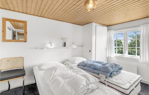 グドイェムにあるBjlkenの白い壁と木製の天井が特徴の客室で、ベッド2台が備わります。