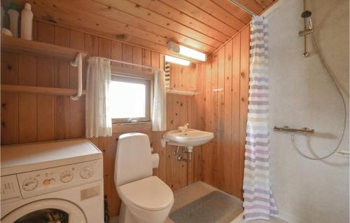 a bathroom with a toilet and a sink and a washing machine at Awesome Home In Hvide Sande With 3 Bedrooms And Wifi in Nørre Lyngvig