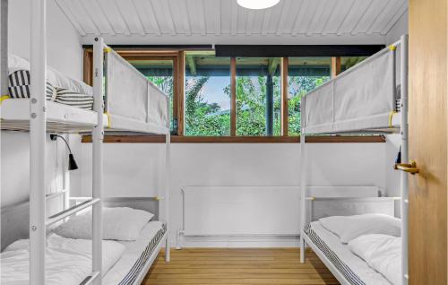 ジルレジェにあるStunning Home In Gilleleje With 5 Bedrooms And Wifiの二段ベッド3組、窓が備わる客室です。