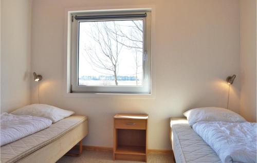 ロモ・キルケビーにある2 Bedroom Cozy Home In Rmのベッド2台と窓が備わる客室です。