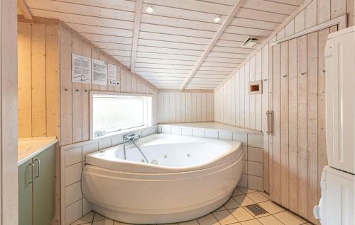 Beautiful Home In Nex With 4 Bedrooms, Sauna And Wifi في Balke: حمام مع حوض كبير ونافذة