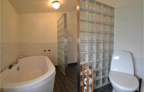 een badkamer met een bad, een toilet en een wastafel bij Gorgeous Home In Fan With Kitchen in Fanø