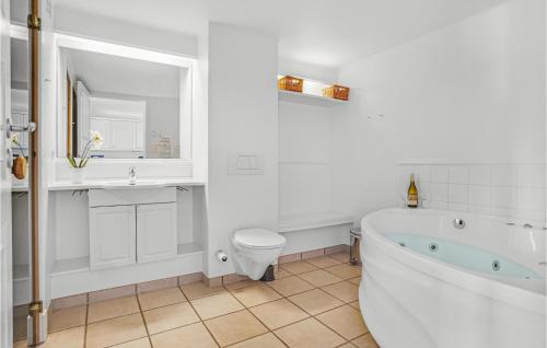 y baño con bañera, aseo y lavamanos. en Stunning Apartment In Nykbing Sj With 2 Bedrooms, Sauna And Wifi, en Nykøbing Sjælland