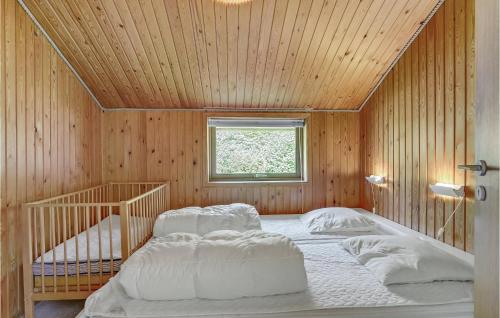3 Bedroom Pet Friendly Home In Toftlund في Arrild: سريرين في غرفة خشبية مع نافذة