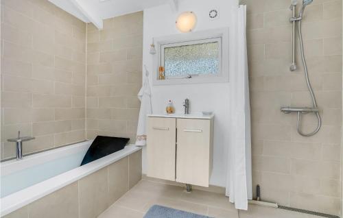 ein Bad mit einer Badewanne, einem Waschbecken und einer Dusche in der Unterkunft 4 Bedroom Awesome Home In Skibby in Skibby