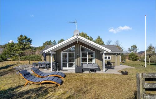 een huis met twee ligstoelen ervoor bij 3 Bedroom Nice Home In Hadsund in Hadsund