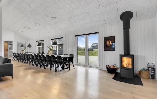 a dining room with a fireplace and a long table and chairs at Nice Home In Sydals With Sauna in Sarup