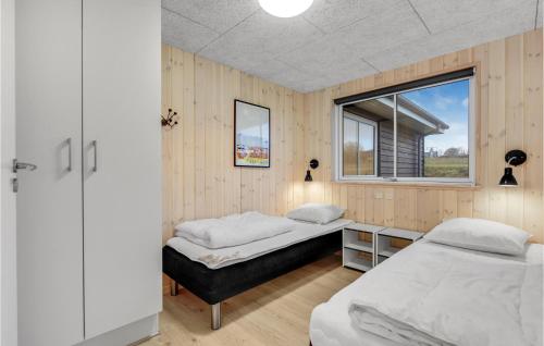two beds in a room with a window at Nice Home In Sydals With Sauna in Sarup