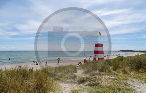 a group of people on a beach with a red and white lighthouse at Nice Home In Sydals With Sauna in Sarup