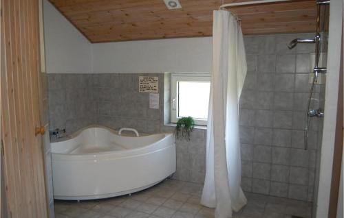 a white tub in a bathroom with a window at Gorgeous Home In Hvide Sande With Ethernet Internet in Havrvig