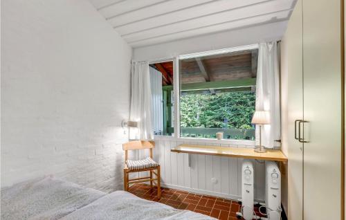 1 dormitorio con cama, ventana y silla en Awesome Apartment In Allinge With Kitchen, en Allinge