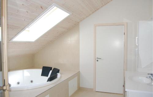a bathroom with a tub and a sink and a skylight at Stunning Home In Idestrup With Wifi in Bøtø By
