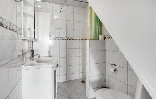 Baño blanco con lavabo y aseo en Lovely Home In Rdekro With Kitchen, en Diernæs