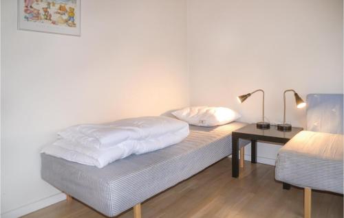 a bedroom with a bed and a desk with a lamp at Nice Home In Nrre Nebel With Wifi in Nørre Nebel