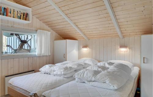 a bedroom with a bed with white blankets and pillows at Four-Bedroom Holiday Home In Dronningmolle in Dronningmølle