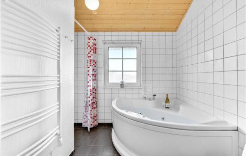 a white bathroom with a tub and a window at 3 Bedroom Nice Home In Nrre Nebel in Nørre Nebel