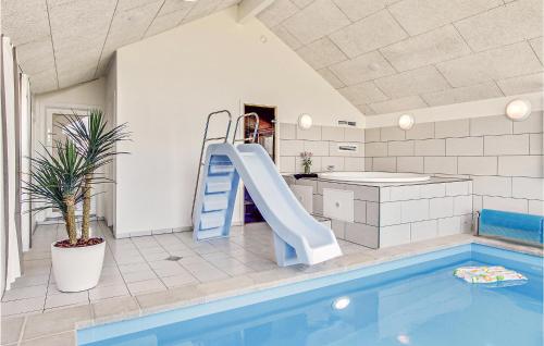 SkåstrupにあるAmazing Home In Bogense With 5 Bedrooms, Sauna And Wifiの家屋内の滑り台付きスイミングプール