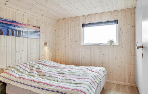 Lovely Home In Bogense With Kitchen في Skåstrup: غرفة نوم بسرير في جدار خشبي