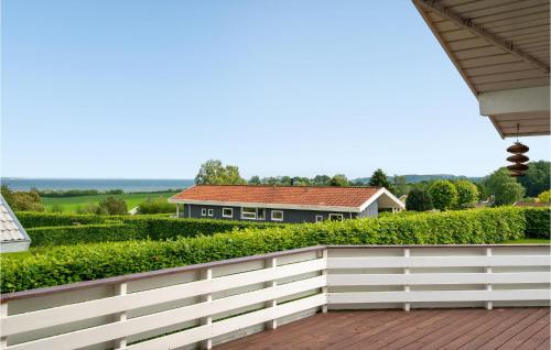 una cerca blanca con una casa en el fondo en Gorgeous Home In Hejls With Sauna, en Hejls