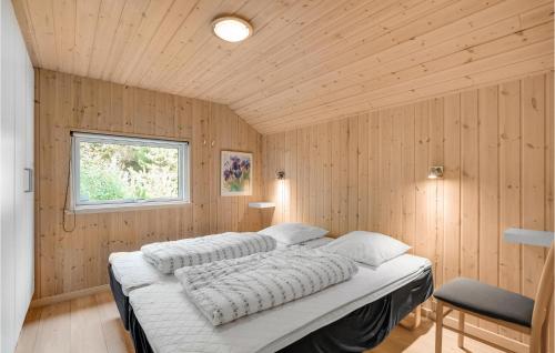 1 Schlafzimmer mit 2 Betten an einer Holzwand in der Unterkunft Awesome Home In Rm With 4 Bedrooms, Sauna And Wifi in Rømø Kirkeby