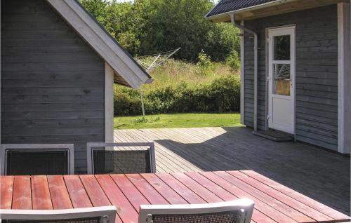 a wooden deck with two chairs on a house at Holiday Home Tranekær With Sea View 06 in Lohals