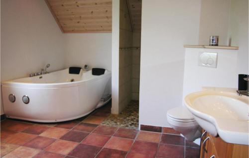 a bathroom with a tub and a toilet and a sink at Holiday Home Tranekær With Sea View 06 in Lohals