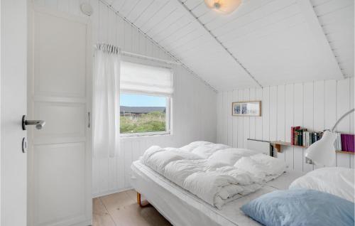 BjerregårdにあるCozy Home In Hvide Sande With Wifiの白いベッドルーム(ベッド1台、窓付)