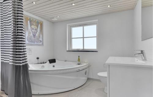 bagno bianco con vasca e servizi igienici di Cozy Home In Bagenkop With Sauna a Bagenkop