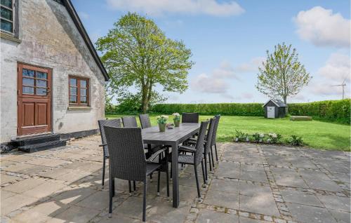 a dining table and chairs on a patio at Amazing Home In Søllested With Wifi in Søllested