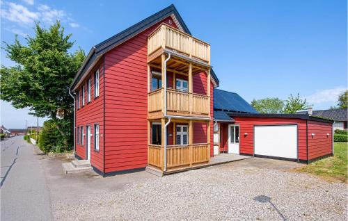 a red house with a balcony on top of it at Three-Bedroom Apartment In Bagenkop in Bagenkop
