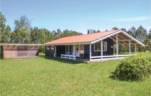 a house with a red roof and a yard at Three-Bedroom Holiday Home In Norre Nebel in Nørre Nebel