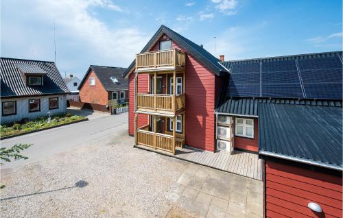 a red house with a balcony on the side of it at Three-Bedroom Apartment In Bagenkop in Bagenkop