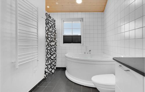 a white bathroom with a tub and a toilet at Amazing Home In Nrre Nebel With Wifi in Nørre Nebel