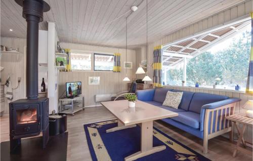 a living room with a blue couch and a wood stove at Three-Bedroom Holiday Home In Norre Nebel in Nørre Nebel