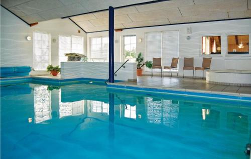 ブラーバンドにあるAwesome Home In Blvand With 5 Bedrooms, Wifi And Indoor Swimming Poolの家の中の椅子付きスイミングプール