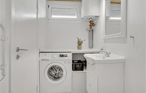 uma cozinha branca com uma máquina de lavar roupa e um lavatório em Nice Home In Hjrring With Kitchen em Lønstrup