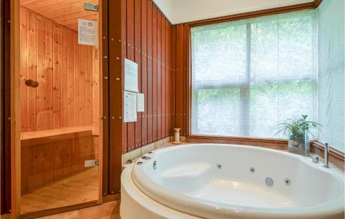 een groot bad in een badkamer met een raam bij Nice Home In Ebeltoft With Kitchen in Ebeltoft