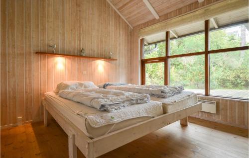 een slaapkamer met een groot bed in een kamer met een raam bij Nice Home In Ebeltoft With Kitchen in Ebeltoft