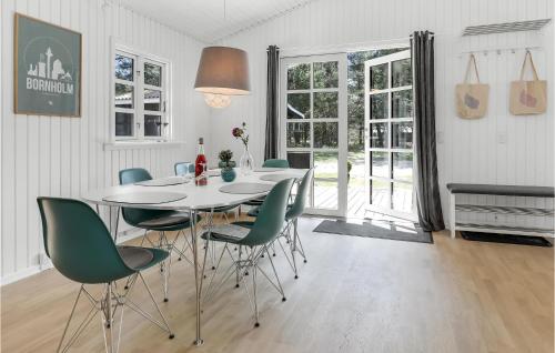 a dining room with a white table and green chairs at Holiday Home Havrebakken in Vester Sømarken