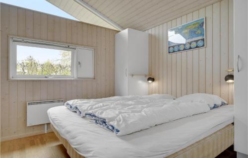 a large white bed in a room with a window at Cozy Home In Dronningmlle With Sauna in Dronningmølle