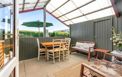 a patio with a table and chairs and a pergola at 1 Bedroom Nice Home In Stege in Stege