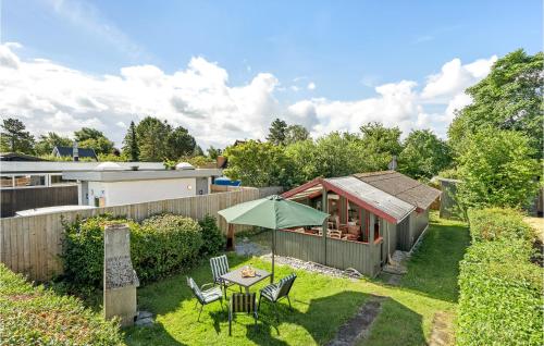 a garden with a small house with a table and an umbrella at 1 Bedroom Nice Home In Stege in Stege