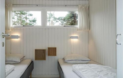 two beds in a room with a window at Awesome Home In Nex With Kitchen in Vester Sømarken